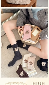 Detail view of winter wool socks featuring cute 3D plush bear motifs and ribbed cuffs