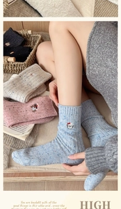 Detail of wool blend thick socks with cute animal embroidery and colorful flecked knit