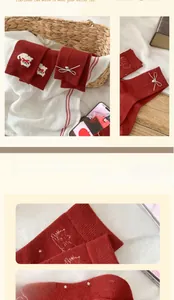 Detail of burgundy wool socks with cat embroidery and bow accents on knitted fabric