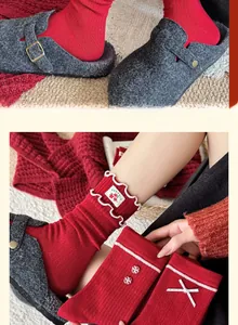 Détails de chaussettes rouges festives avec des nœuds élégants et des bords froncés
