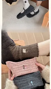 Détail de chaussettes en laine tricotées avec broderie chat et chaussures Mary Jane