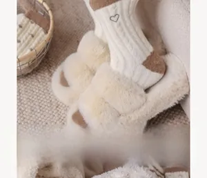 Gros plan de chaussettes blanches côtelées avec broderie cœur et chaussons en peluche