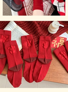Close-up of red festive cotton socks featuring embroidered Chinese fortune characters