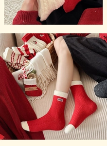 Close-up of thick plush Christmas socks in red and white with festive holiday decorations
