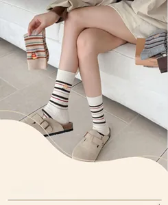 Détail de chaussettes en coton avec rayures colorées et broderie frites mignonne