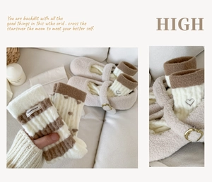 Détail de chaussettes rayées et chaussons en peluche avec broderie coeur sur canapé blanc