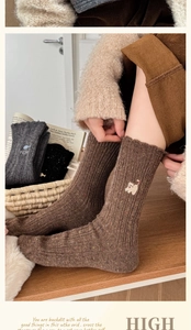 Détail de chaussettes en laine avec fil moucheté et broderie chat mignon pour l'hiver