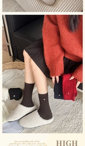 Detail of wool blend ribbed mid-calf socks with small animal metallic logo decoration