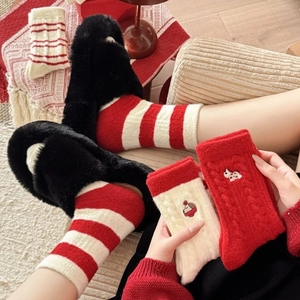 Thick warm red and white Christmas socks set with embroidery in a cozy winter setting