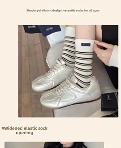 Detail of widened elastic cuff on retro striped cotton crew socks with handmade label