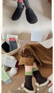 Detail view of colorful wool socks paired with fur-lined mules in a cozy indoor setting
