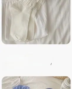 Detailed view of white knitted mid-calf socks with sweet ruffled edges and soft texture