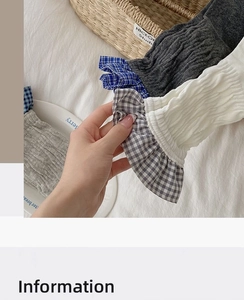 Detail of ribbed knit cotton socks featuring blue gingham patterns and ruffle cuffs