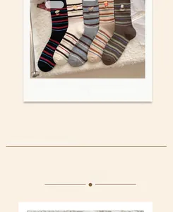Détail de chaussettes à rayures avec broderies d'oeuf et de pain sur tissu texturé