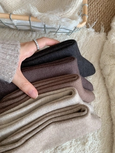 Gros plan de cinq paires de chaussettes en maille épaisse aux couleurs neutres d'automne