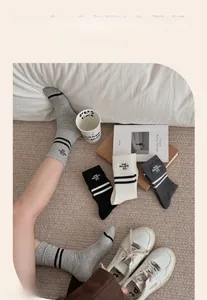 Detail of striped cotton athletic socks with Step Graceful embroidery and ribbed texture