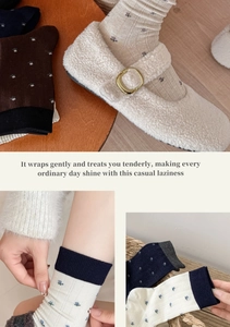 Detail of floral wool socks and plush Mary Jane shoes with golden buckle and blue trim