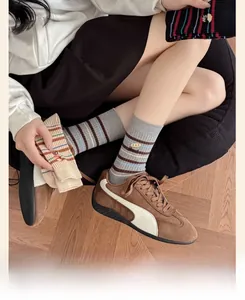 Détail des chaussettes mi-hautes en coton à rayures gris et beige avec bords côtelés