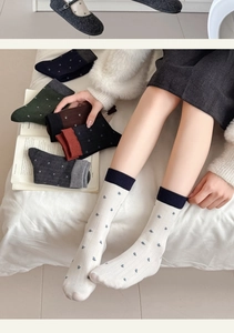 Detail of wool socks with floral embroidery and ribbed texture in various colors