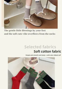 Detail of color-block knit cotton crew socks featuring handmade label and ribbed texture