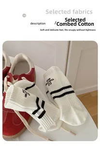 Detail of white cotton sports socks with black stripes and letter embroidery