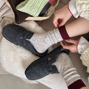 Thick wool socks in speckled knit paired with felt clogs for autumn and winter warmth