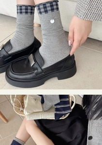 Nahaufnahme von gerippten Ballettsocken mit Vintage-Karomuster und Metallelementen