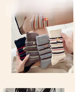 Détail de chaussettes montantes côtelées avec rayures et broderies de petit-déjeuner mignon