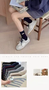 Detail showing various colors of striped wool mid-calf socks with woven label accents