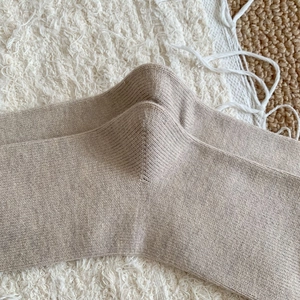 Détail du talon renforcé et de la texture côtelée fine sur des chaussettes en coton beige