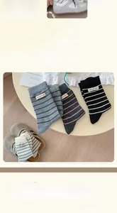Detailed view of cozy wool blend striped crew socks with stitched letter patches