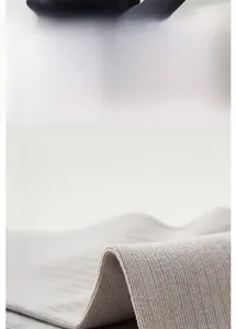 Macro detail of breathable grey ribbed cotton fabric showing high-quality knit texture