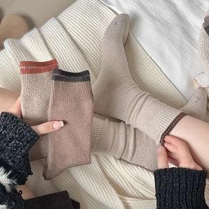 Chaussettes d'automne en tricot aux tons terre sur fond de couverture douce