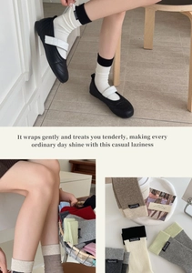 Detail of color-block ribbed socks with Handmade label paired with black Mary Jane shoes