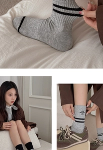 Macro detail of ribbed cotton socks featuring double black stripes and athletic lettering