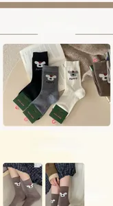 Dettaglio della trama a maglia delle calze in lana con motivo a cucciolo in vari colori