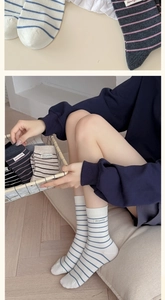 Detailed view of striped wool socks with textile labels and ribbed cuffs in various colors