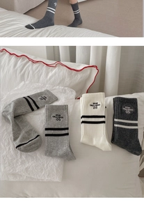 Detail of striped cotton socks with Step Graceful embroidery and ribbed knit texture