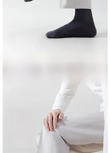 Macro detail of dark grey mid-calf cotton sock showing reinforced heel and ribbed cuff texture