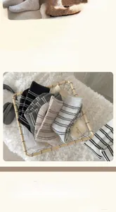 Close-up of thick striped wool socks in neutral tones showing cozy ribbed texture