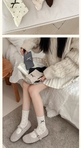 Detailed view of grey wool socks with black polka dots and sweet bow tie decorations