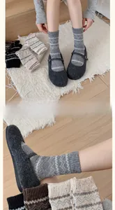 Dettaglio macro di calze di lana lavorate a maglia con motivi geometrici e scarpe Mary Jane