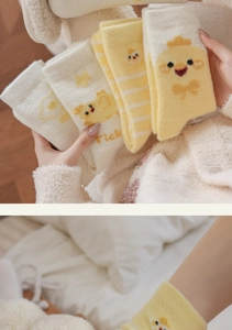Détail montrant des chaussettes poussin jaunes en polaire douce avec motifs