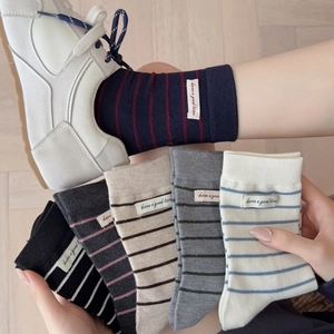 Cozy wool blend striped socks with woven labels in six assorted colors on wooden floor