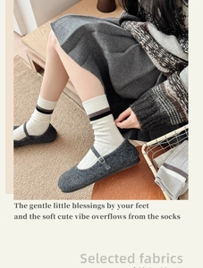 Gros plan de chaussettes en laine à rayures avec chaussures Mary Jane et jupe plissée