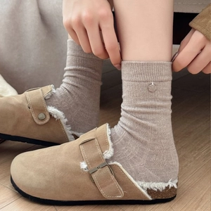 Winter wool socks with clogs, stylish slouchy thermal hosiery for women on wood floor