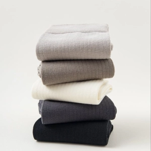 Vertical stack of breathable cotton mid-calf socks in five neutral ribbed color tones