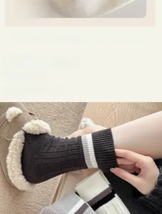 Détail de chaussettes en laine gris foncé à rayures et pantoufles en peluche douce