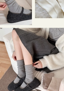 Detail of grey ribbed knit mid-calf socks paired with plush Mary Jane shoes in winter style