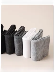 Detail of stacked cotton socks showing knitted texture and breathable fabric in neutral tones